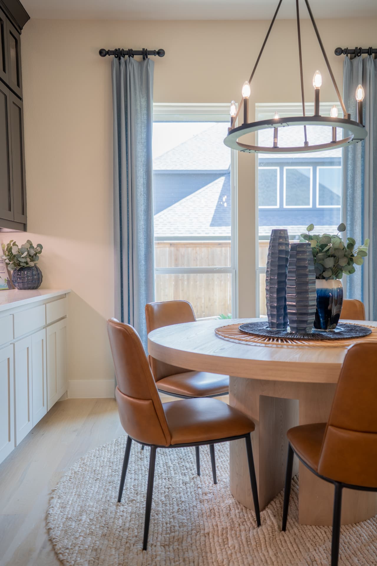 Sunlit dining nook with round oak table and leather chairs