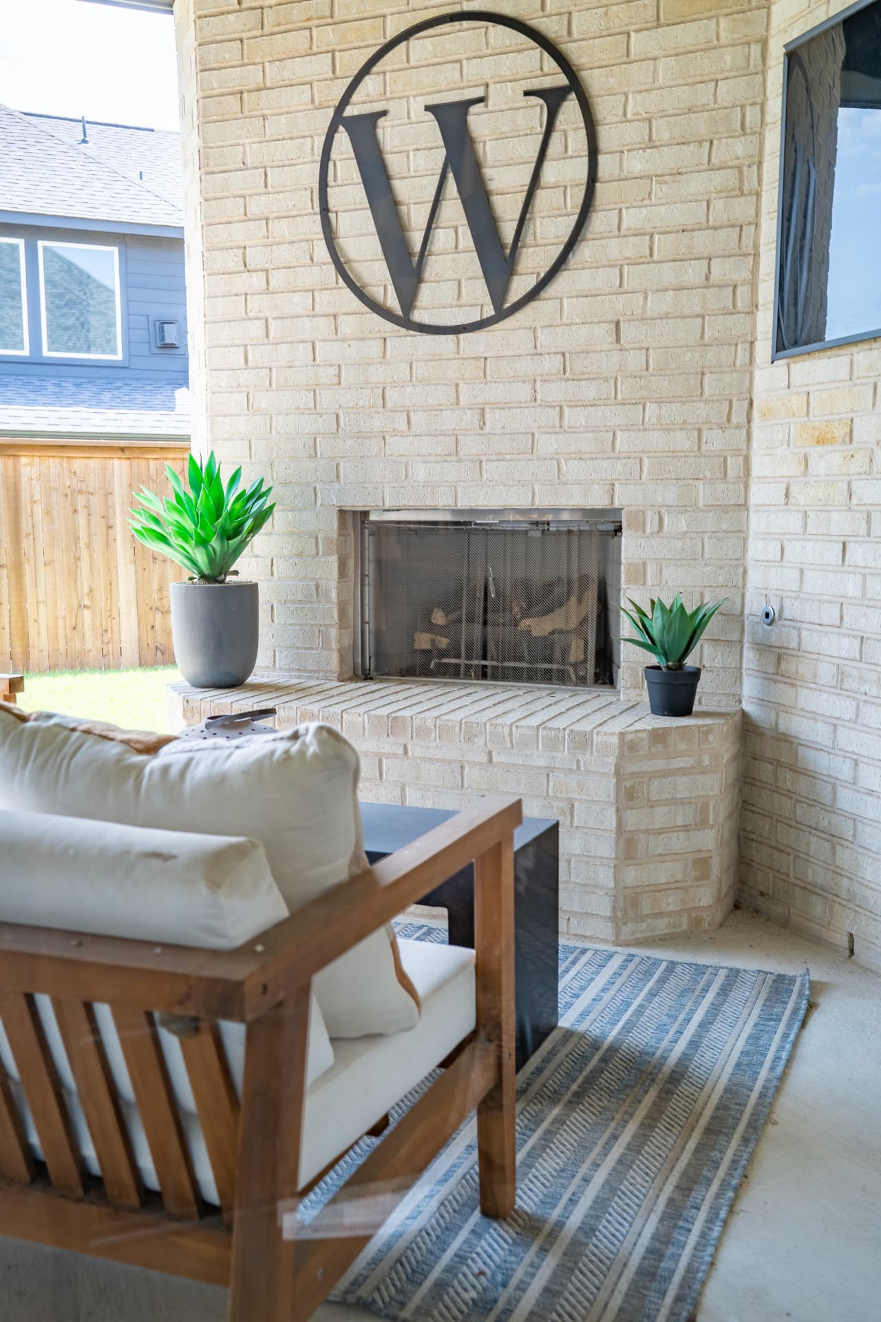 Covered outdoor living space with brick fireplace